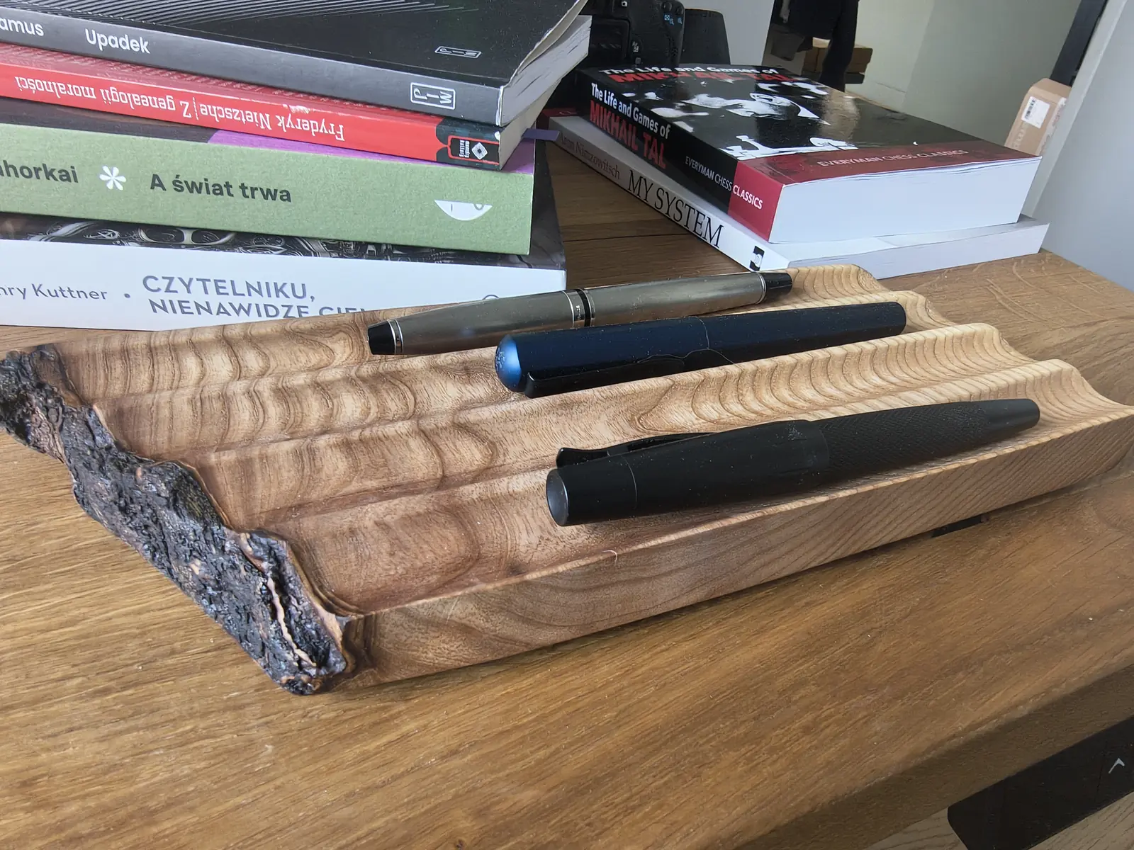 Skidbladnir — perspective view, three pens in channels, live edge at the front